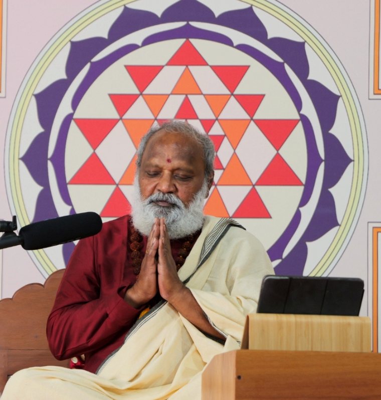 Guruji greeting seekers with folded hands before the Sri Yantra